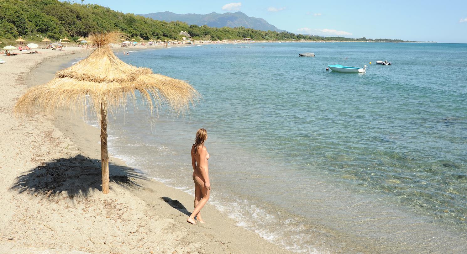 Palmboomparaplu op het strand van Bagheera - naturistencamping Corsica