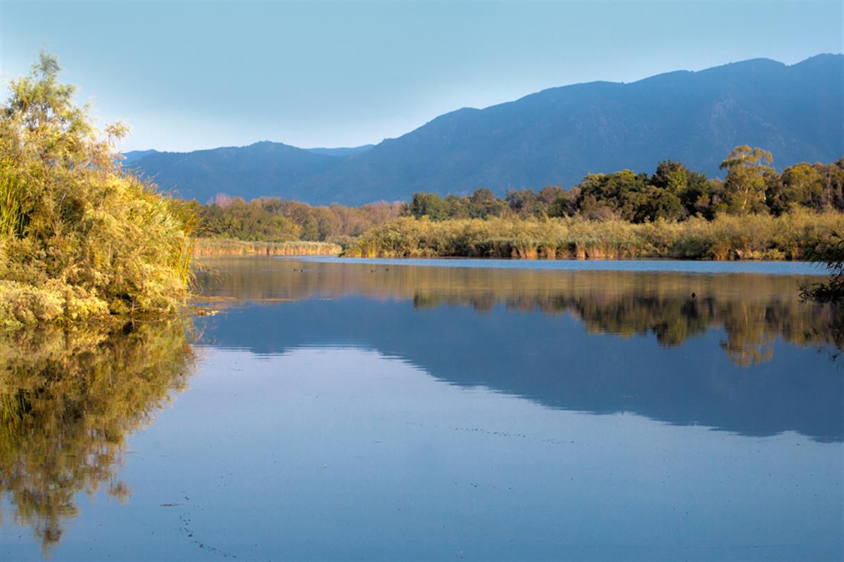 vijver met uitzicht op de bergen - Domaine de Bagheera, naturistencamping op Corsica
